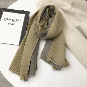 Detail view of khaki and grey linen scarf with seersucker texture and flower pendant