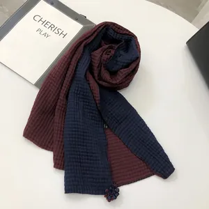 Detailed waffle texture of two-tone linen scarf with delicate handmade flower pendant