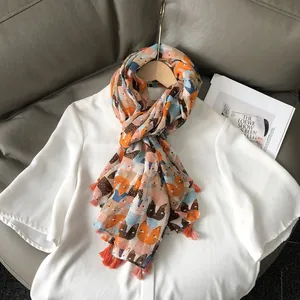 Écharpe légère en coton et lin avec imprimé chat et pompons orange sur un cintre