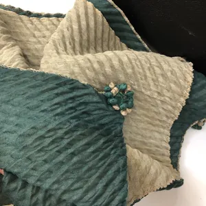 Detail of dark green and cream pleated scarf with handcrafted fabric flower accents