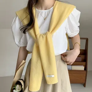 Dettaglio dello scialle in maglia 100% lana australiana con focus su etichetta materiale