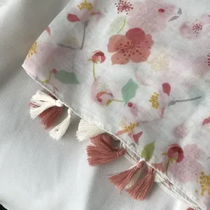 Detail of floral printed cotton linen shawl with bicolored pink and cream tassels