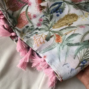 Close-up of floral print scarf with green leaves and pink fringe tassels decoration
