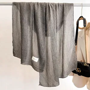 Gray pleated cotton linen scarf draped with a vintage tie-dye texture and woven label