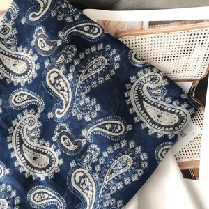 Detail shot of navy blue paisley print scarf on a magazine background for lifestyle context