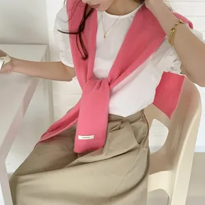 Dettaglio dello scialle in 100% lana australiana rosa acceso con trama in maglia morbida