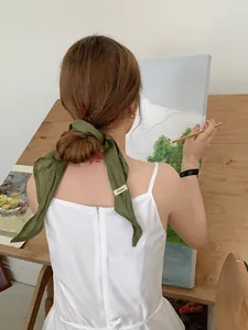 Close-up of dark green 100% linen scarf tied on a hair bun in an artistic studio