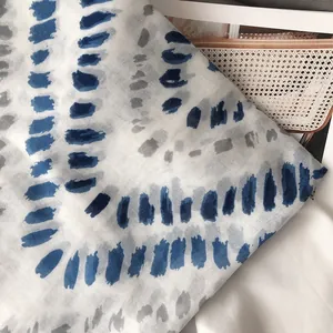 Vue détaillée d'une écharpe à pois dégradés bleu et gris avec des bords à franges douces