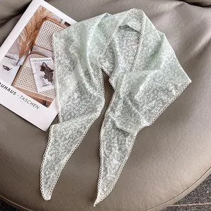 Foulard in pizzo verde chiaro con stampa floreale e farfalle su pelle grigia