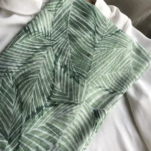 Gros plan détaillé de l'écharpe à imprimé palmier tropical avec glands sur tissu
