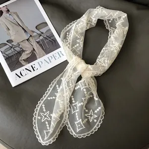 Elegante witte kanten sjaal en vintage haarlint op een achtergrond van modebladen