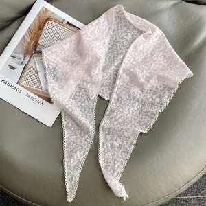 Dettaglio foulard a triangolo in pizzo floreale con ricamo a farfalla e bordi smerlati
