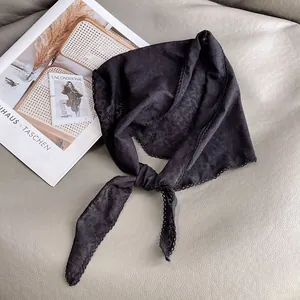 Dettaglio del bordo in pizzo nero e motivo jacquard su una bandana in stile vintage