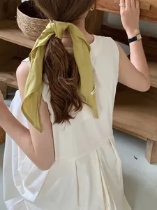 Rear view of long mustard green linen hair ribbon styled with a white pleated dress