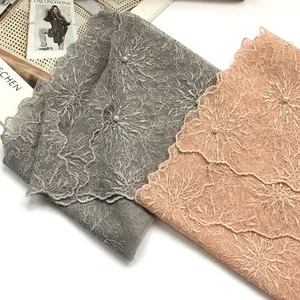 Macro detail of lace scarf with 3D flower embroidery, white pearls and sequins