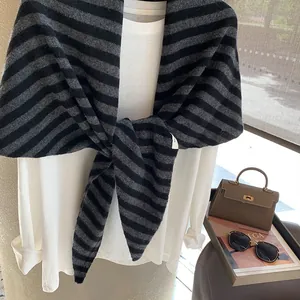 Bufanda de lana a rayas negras y grises de estilo minimalista sobre camisa blanca