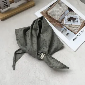 Detailed view of the 100% linen triangle scarf with delicate floral patterns