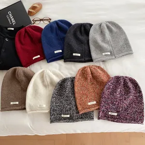 Flat lay of 100% wool knitted beanies in various colors for winter warmth