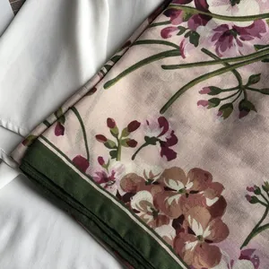 Détail de l'écharpe à fleurs rose poudré avec bords verts et ourlets roulés fins