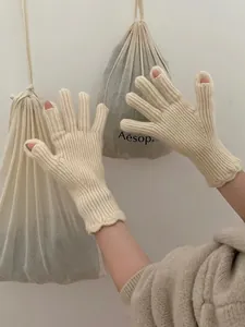 Close-up of knit gloves featuring elastic ribbed cuffs and delicate scalloped edge details