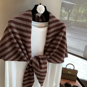 Detalle de bufanda triangular de lana a rayas anudada sobre una camiseta blanca