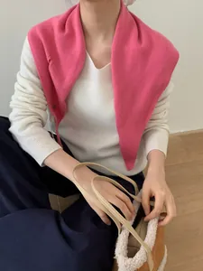 Detalle del chal de lana rosa sobre jersey blanco y bolso de mano de felpa