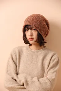 Detailed close-up of orange-brown melange knit beanie with thick ribbed texture