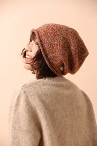 Detailed knit texture and raw edge design of a warm orange-brown wool beanie for winter