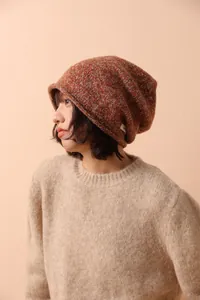Close-up of wool melange knit beanie with cuffed edge and woven logo patch