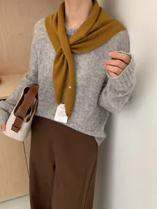 Textura detallada de jersey de lana gris combinado con un chal triangular amarillo fino