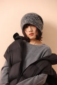Detail of a dark gray speckled wool knit beanie showing texture and winter styling