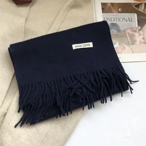Detailed view of dark blue 100% Australian wool scarf featuring soft fringe and quality tag