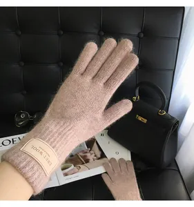 Detail von Wollstrickhandschuhen mit Lederetikett und elegantem Touchscreen-Design