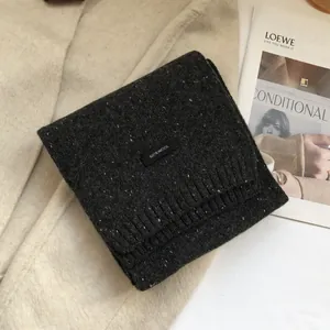 Detail of 100% wool knit scarf in charcoal grey with white speckles and ribbed edges