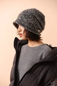 Detail shot of the 100% pure wool knit beanie texture with a minimalist white fabric patch