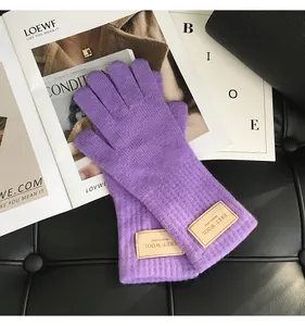 Detaillierte Strickstruktur der Handschuhe aus 100% australischer Wolle mit Lederetikett