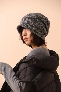 Detail view of the chunky knit wool texture and short brim on this winter beanie hat