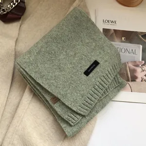 Close-up of sage green 100% wool knit scarf with colorful nep yarn and ribbed edges