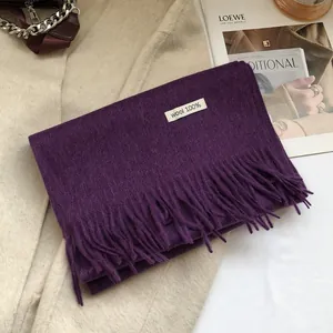 Detail of premium purple 100% wool scarf featuring elegant long tassel fringe textures