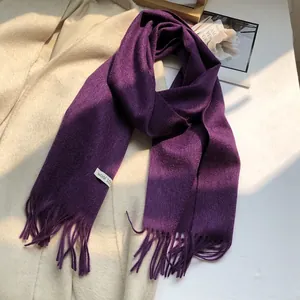 Close-up of premium dark purple wool scarf with fine tassels and soft fuzzy texture