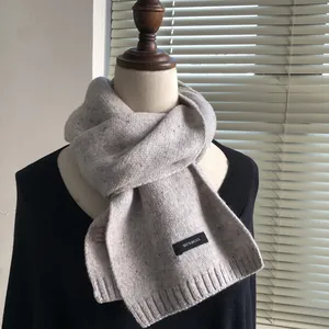 Detail of grey 100% wool knitted scarf showing fiber texture and rib-knit finish