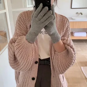 Close-up of grey knit gloves with vertical ribbed texture and warm wrist cuffs