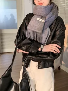 Detail eines Schals aus 100% Wolle mit grau-blauem Farbverlauf und Premium-Qualitätssiegel