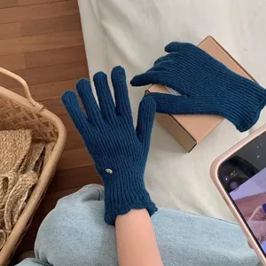 Detail showing navy knit gloves with vertical ribbed texture and wavy scalloped cuffs