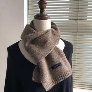 Detail of 100% wool knit scarf in brown with colorful speckles and ribbed edges