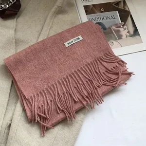 Detail of pink 100% Australian wool scarf with tassels on fashion magazine