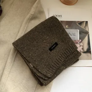 Detail of soft 100% wool knitted scarf in dark brown with textured star pattern