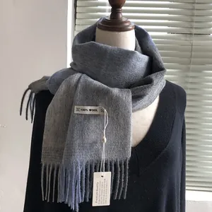 Detail eines Schals aus 100% Wolle mit grau-blauem Farbverlauf und eleganten Fransen
