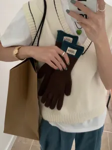 Close-up of knit touchscreen gloves with green contrast cuff and stylish brand label