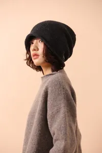 Close-up of dark grey pure wool knitted beanie worn with a thick textured sweater